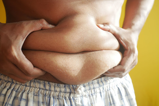 Man gripping his belly fat.